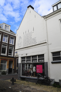 904759 Gezicht op de zijgevel van het pand Herenstraat 23 te Utrecht, vanaf de Oude Kamp, met een gedicht en tekening ...